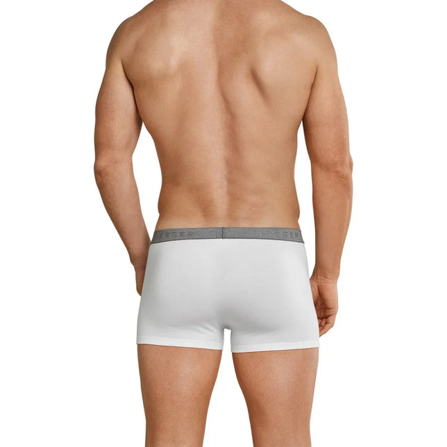 Achteraanzicht van man in witte Schiesser herenboxer low rise met korte pijpen en grijze logotailleband. - Jambelles