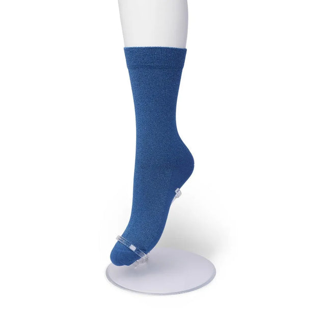 Blauwe Bonnie Doon Cotton Sparkle damessok met subtiele glans en effen dessin op een witte paspopvoet. - Jambelles