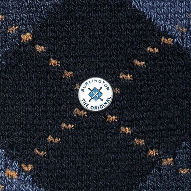 Close-up van Burlington Preston SO 24284 herensok in donkerblauw breisel met bruine motiefjes en rond merklabel. - Jambelles