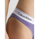 Model draagt paarse Calvin Klein dames bikinislip 0000F3787E met witte logoband en bijpassende bralette. - Jambelles