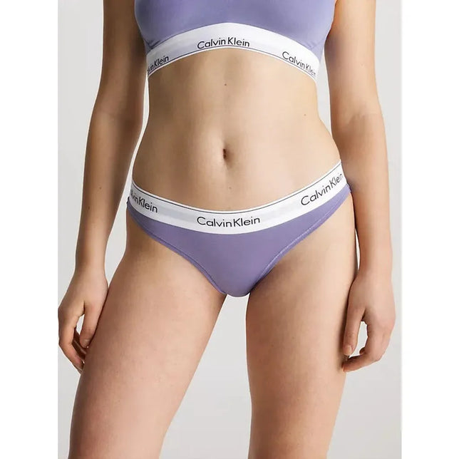 Calvin Klein dames bikinislip 0000F3787E in lila, gedragen door een model, met witte logoband. - Jambelles