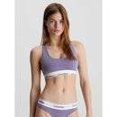 Model draagt paarse Calvin Klein Icon Cotton Modal bralette met brede bandjes en witte logoband. - Jambelles