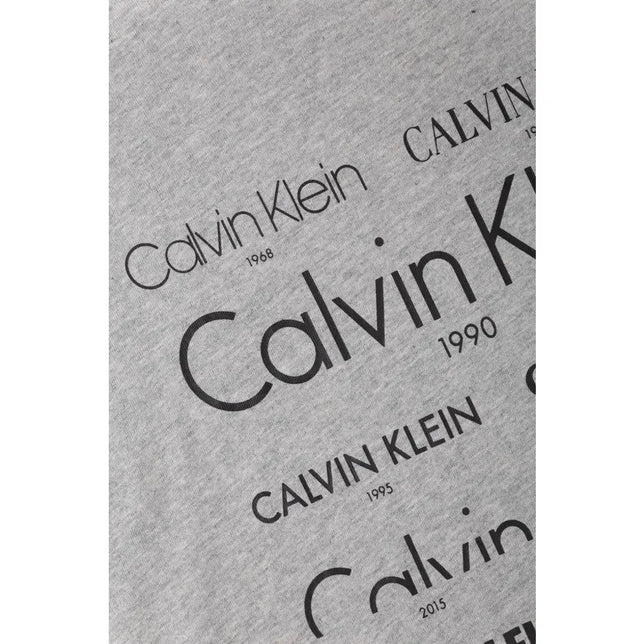 Detail van grijs Calvin Klein heren-T-shirt 000Nm1438E met zwarte logoprints en jaartallen. - Jambelles