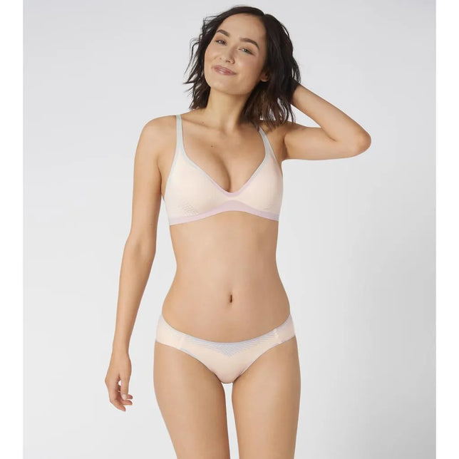 Model draagt een lichtroze sloggi BODY ADAPT T-shirtbralette met V-hals, dunne bandjes en lila boorden. - Jambelles