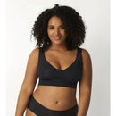 Damesmodel van achteren in zwarte sloggi BODY ADAPT bralette met brede bandjes, gladde stof en diepe ronde rug. - Jambelles