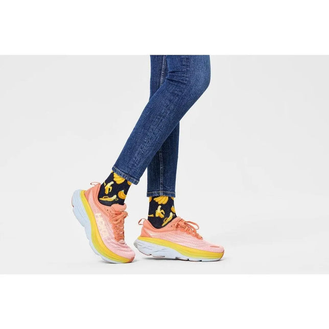 Donkerblauwe Happy Socks Banana BAN01 fantasie sokken voor dames en heren met gele bananen, gedragen met roze sneakers. - Jambelles