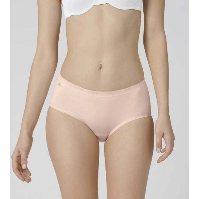 Model draagt een lichtroze sloggi Basic+ Midi damesslip met gladde voorkant en fijne elastische boorden. - Jambelles
