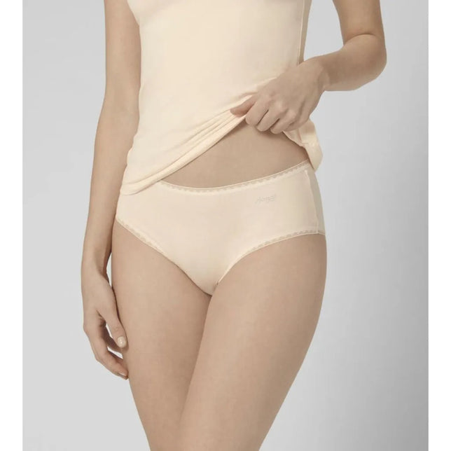 Sloggi dames slip GO Midi C2P 10207340 in beige, gedragen door een model, met fijne sierboord en subtiel logo. - Jambelles