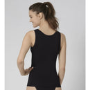 Damesmodel draagt een beige sloggi GO Tank Top C2P van biologisch katoen met brede bandjes en ronde hals. - Jambelles