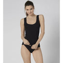 Damesmodel draagt een beige sloggi GO Tank Top C2P van biologisch katoen met brede bandjes en ronde hals. - Jambelles