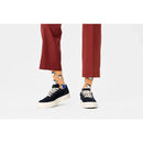 Happy Socks fantasie sokken in oranje met witte en blauwe theekopjes, gedragen bij een rode broek en zwarte sneakers. - Jambelles