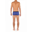 Model draagt de turquoise HOM heren boxer trunk HO1 Plume Up 402373 met zwarte tailleband, biezen en roze detail. - Jambelles
