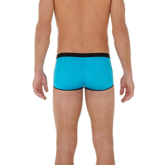 Achteraanzicht van model in turquoise HOM heren boxer trunk HO1 Plume Up 402373 met zwarte tailleband en biezen. - Jambelles