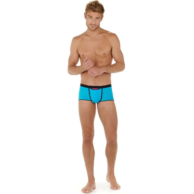 Model draagt de turquoise HOM heren boxer trunk HO1 Plume Up 402373 met zwarte tailleband, biezen en roze detail. - Jambelles