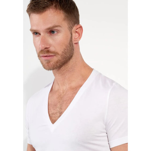 Model draagt wit HOM heren T-shirt Supreme Cotton 401331 met diepe V-hals, korte mouwen en aansluitende pasvorm. - Jambelles