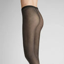 Hudson Dames Panty Diamond 120001766 in zwart, transparant met subtiel ruitpatroon, gedragen met gekruiste benen. - Jambelles