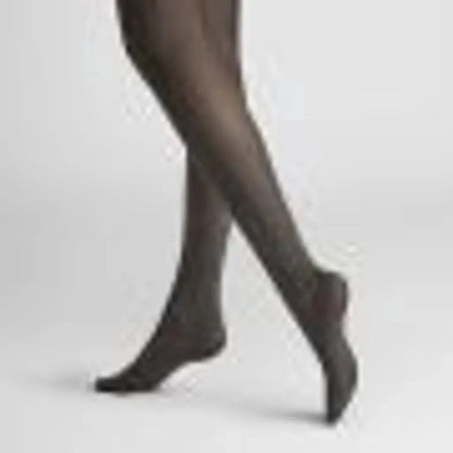 Hudson Dames Panty Diamond 120001766 in zwart, transparant met subtiel ruitpatroon, gedragen met gekruiste benen. - Jambelles