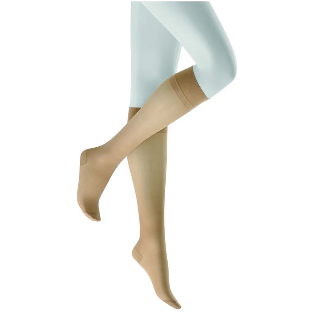 Kunert dameskniekousen FLY&amp;CARE 110198900 in beige, gedragen op een paspop, met brede boord en verstevigde tenen. - Jambelles