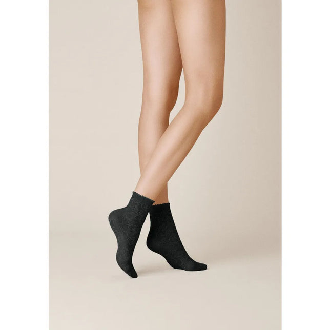 Model draagt zwarte Kunert dames pantysokjes CURL 110162310 met subtiel krulpatroon en een fijne geschulpte boord. - Jambelles