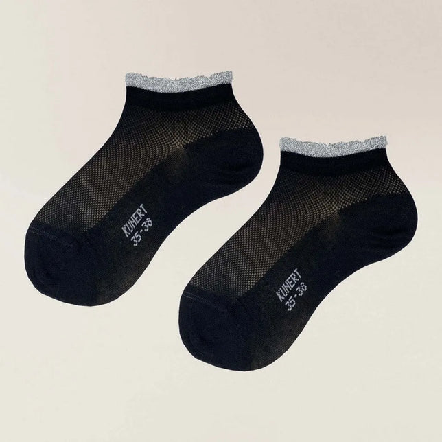 Een paar zwarte Kunert dames sneakersokken GLARE met transparant mesh en een zilverkleurige glitterboord. - Jambelles