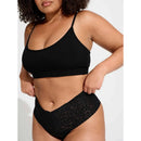 Model draagt de zwarte Lace Laboratory HWT high-waist string van transparant kant met geschulpte rand. - Jambelles