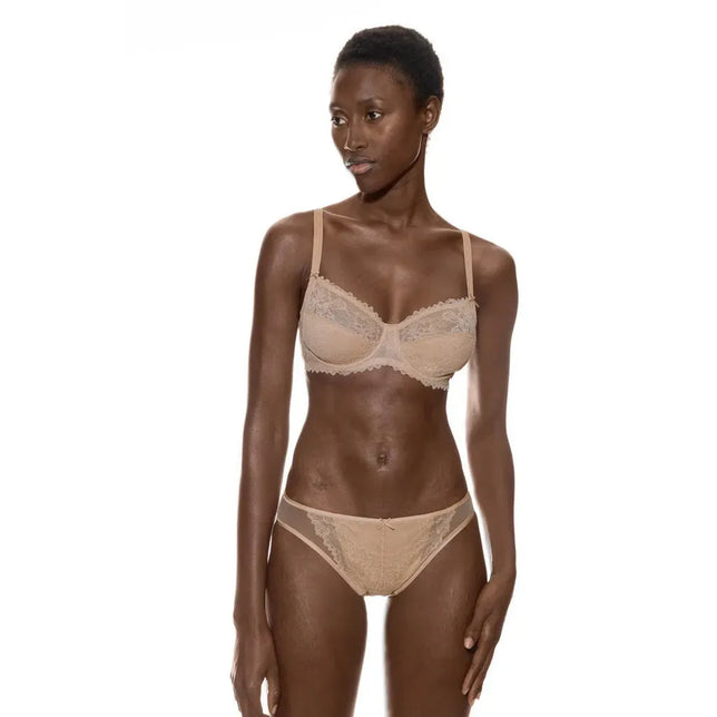 Model draagt de beige Mey Dames BH Wired Bra 1350002 met beugels, kanten cups, verstelbare bandjes en bijpassende slip. - Jambelles