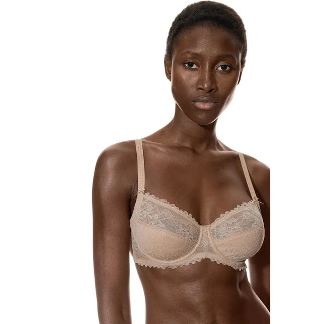 Model draagt de beige Mey dames beugel-bh 1350002 met gebloemde kant, transparante cups en verstelbare bandjes. - Jambelles