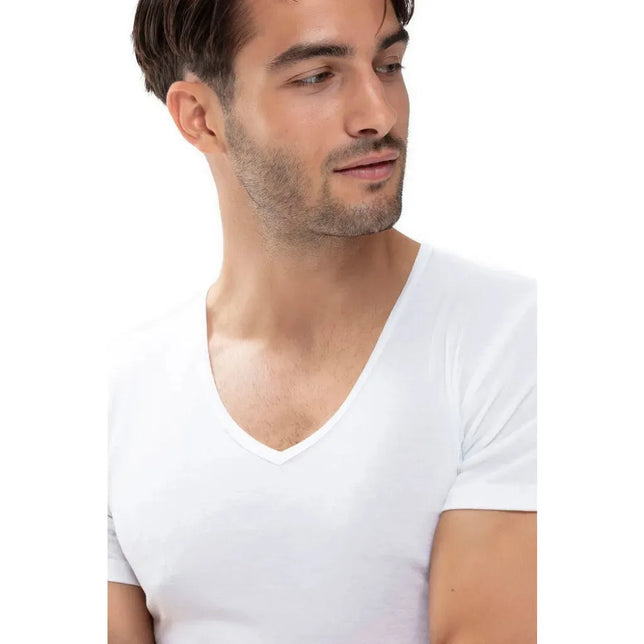 Model draagt een wit Mey Basics 49107 herenshirt met korte mouwen en een diepe V-hals. - Jambelles