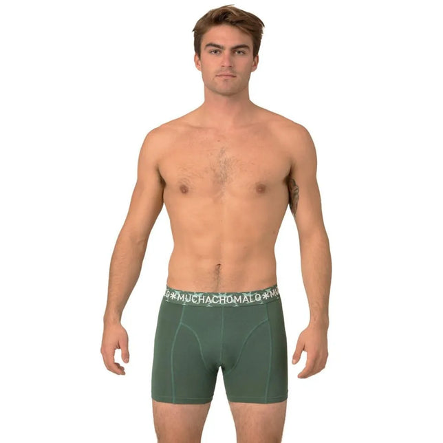 Model in donkergroene Muchachomalo Solid1010 herenboxer met korte pijpen, contrastnaden en logoband. - Jambelles