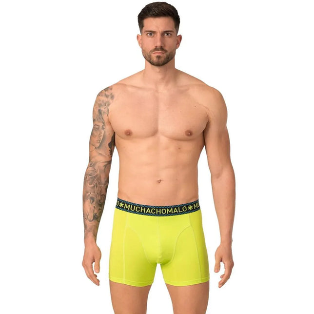 Model draagt een neongele Muchachomalo herenboxer met korte pijpen en donkere logoband. - Jambelles