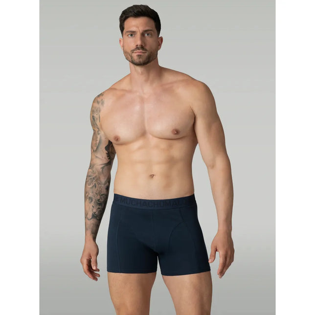 Model draagt een donkerblauwe Muchachomalo herenboxer Solid LCsolid1010 met aansluitende pijpen en logoband. - Jambelles