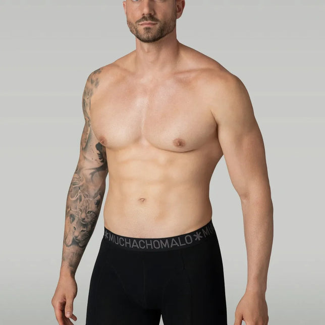 Model draagt een zwarte Muchachomalo herenboxer Solid met aansluitende pasvorm en logoband. - Jambelles
