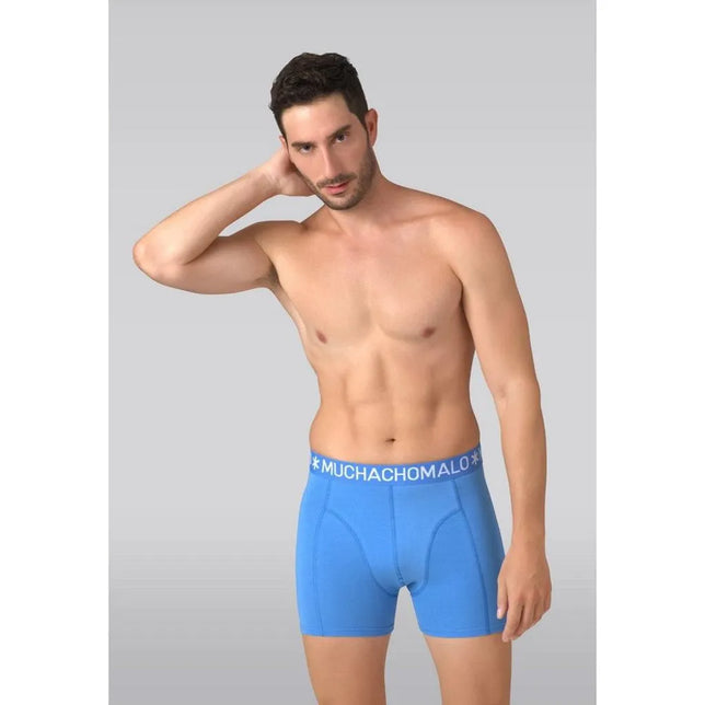 Model draagt een blauwe Muchachomalo herenboxer Solid LCsolid1010 met aansluitende pijpen en elastische logoband. - Jambelles