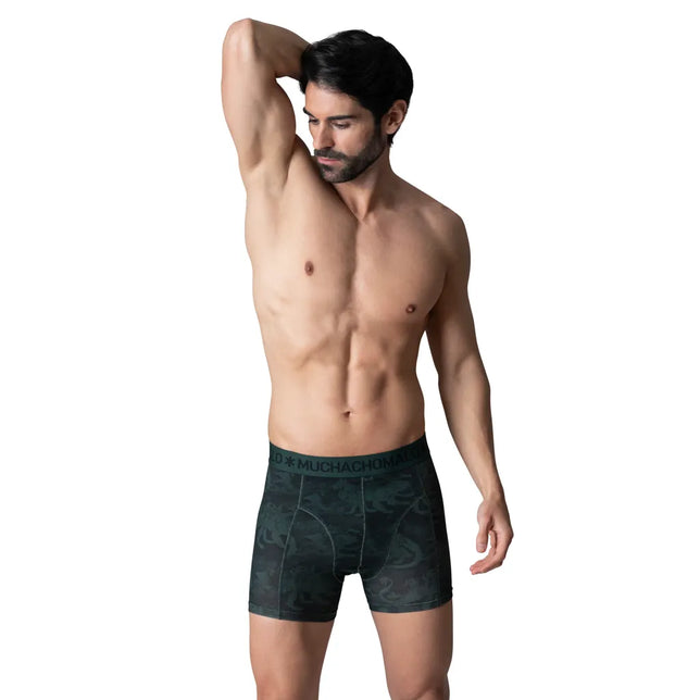 Model in donkergroene Muchachomalo herenboxer BOOGIEKNIGHTS1010 met camouflageprint en logoband. - Jambelles