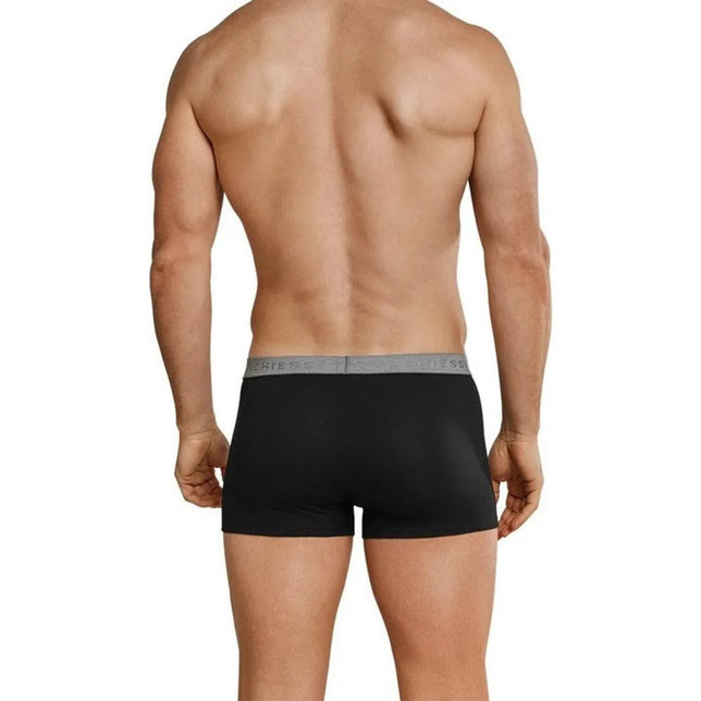 Achteraanzicht van model in zwarte Schiesser Low Rise herenboxer met korte pijpen en grijze logotailleband - Jambelles