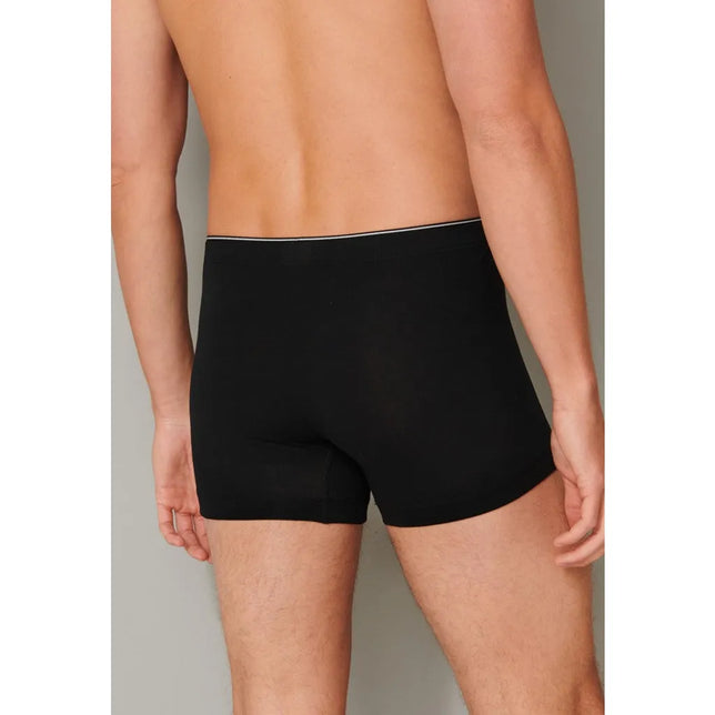 Schiesser heren boxershort 174004 in zwart, achteraanzicht met aansluitende pijpen en smalle witte bies op de tailleband. - Jambelles