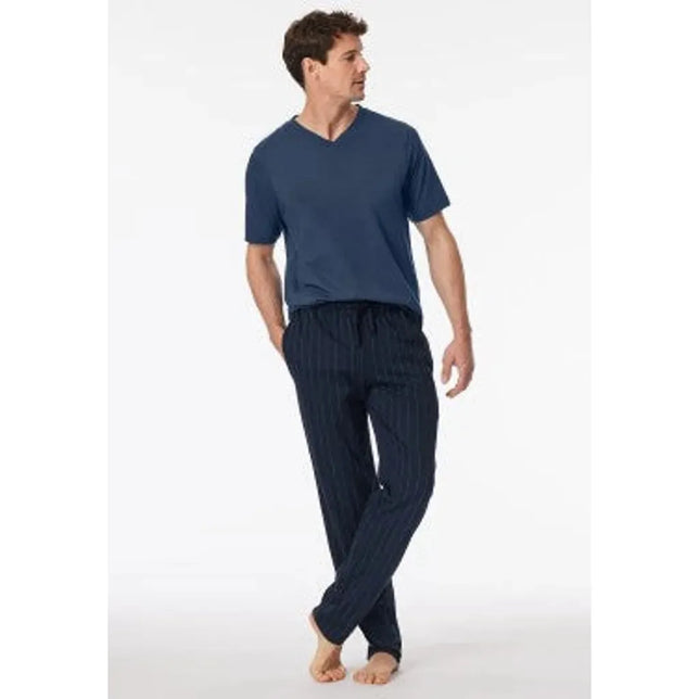 Model draagt de donkerblauwe Schiesser herenbroek lang 182185 met fijne strepen en elastische taille. - Jambelles