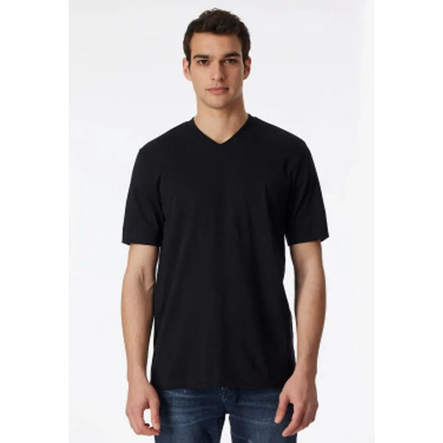 Model draagt zwart Schiesser heren T-shirt 008151 met korte mouwen en V-hals. - Jambelles