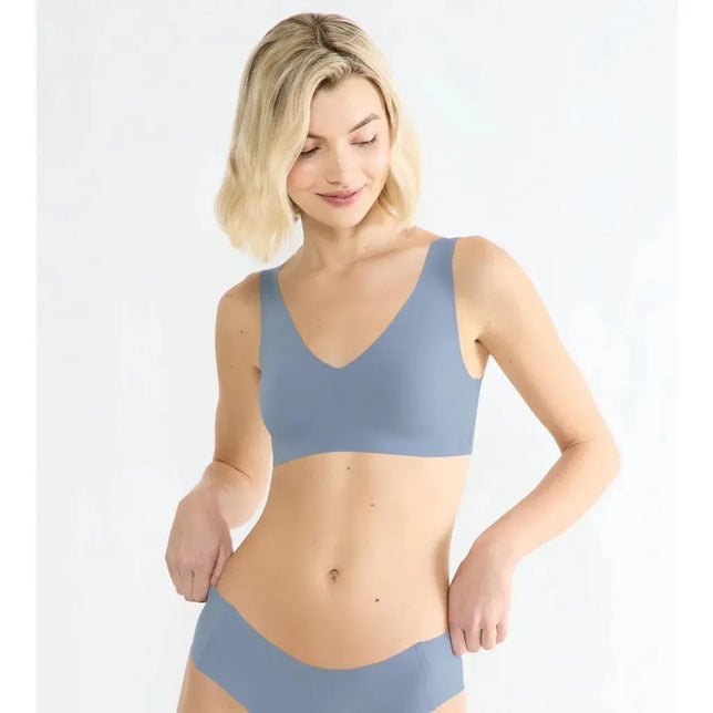 Model draagt de lichtblauwe Sloggi Zero Feel 2.0 damesbralette met V-hals, brede bandjes en naadloze afwerking. - Jambelles