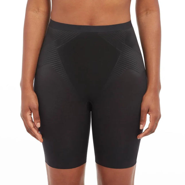 Model draagt zwarte Spanx Thinstincts 2.0 Mid-Thigh damesboxer met hoge taille en geribde zijpanelen. - Jambelles