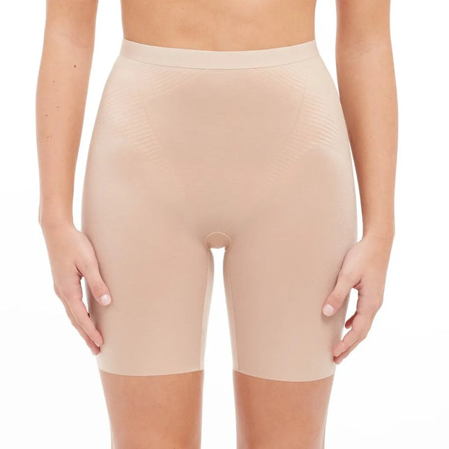 Model draagt de beige Spanx Thinstincts 2.0 damesboxer met hoge taille en pijpen tot halverwege het bovenbeen. - Jambelles