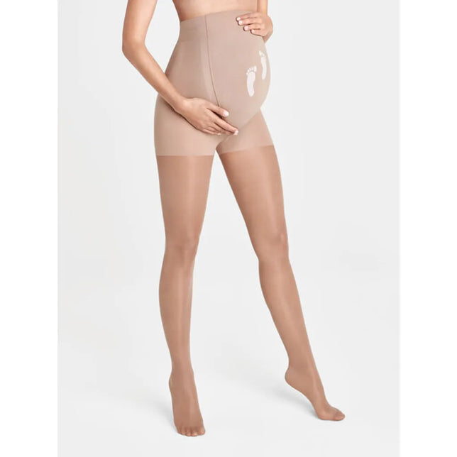 Wolford dames Maternity 30 panty in nude, gedragen door zwangere vrouw, met hoge buikband en witte voetafdrukken. - Jambelles