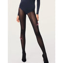 Model draagt Wolford Travel Leg Support panty 14622 in donkerpaars met subtiel diagonaal patroon en zwarte pumps. - Jambelles