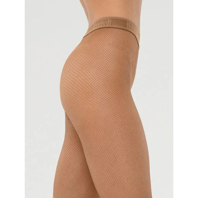 Wolford damespanty Twenties Econyl 19393 in beige, gedragen door een model, met fijn netpatroon en logotailleband. - Jambelles
